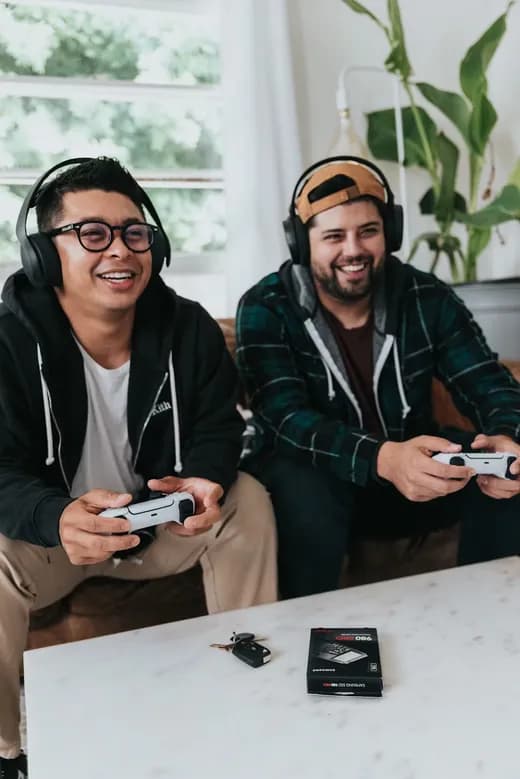 Two friends playing console games with controllers